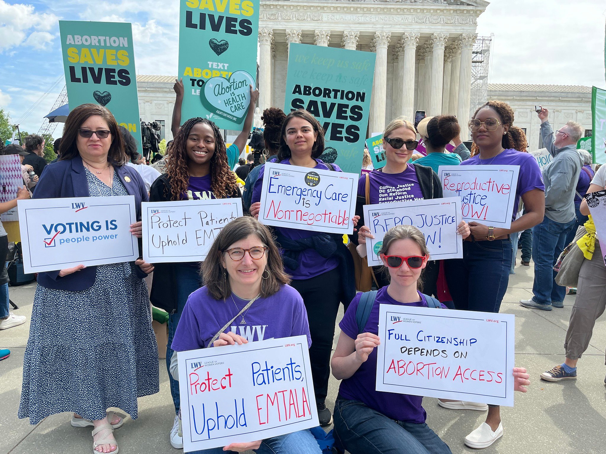 League members rallying in front of the Supreme Court for abortion rights, holding protest signs