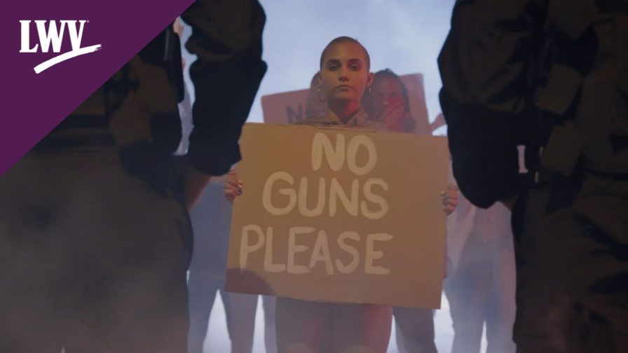 Woman holding a sign that says "no guns please"