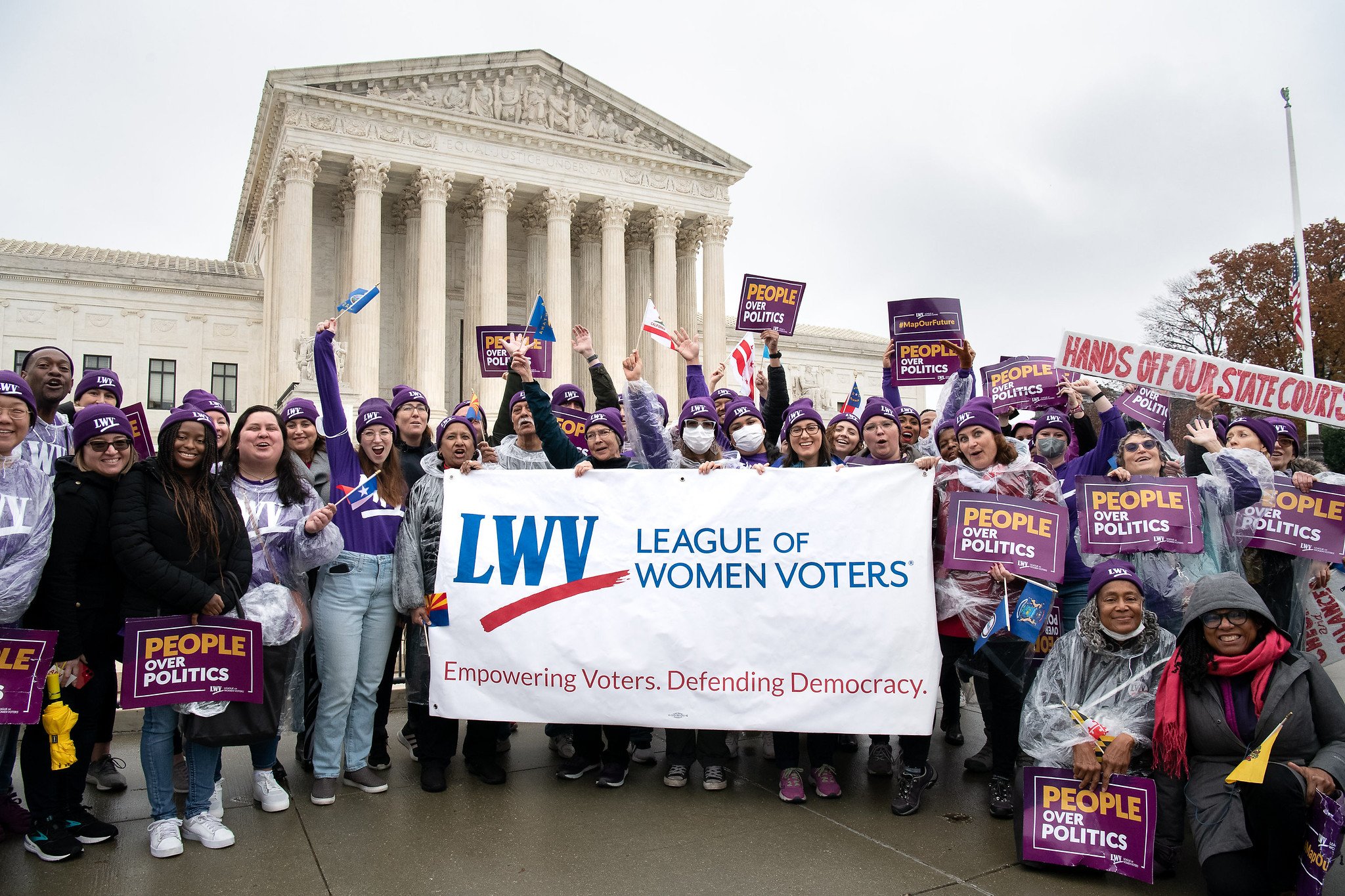 League members in front of the Supreme Court holding an LWV banner