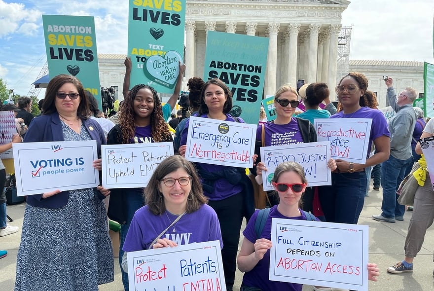 League members rallying in front of the Supreme Court for abortion rights, holding protest signs