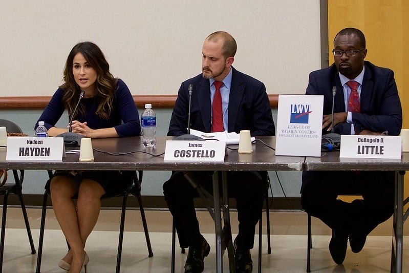 Three candidates seated at a forum