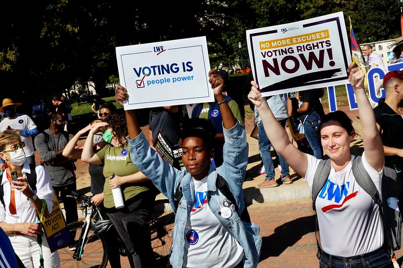 League members holding signs that say 