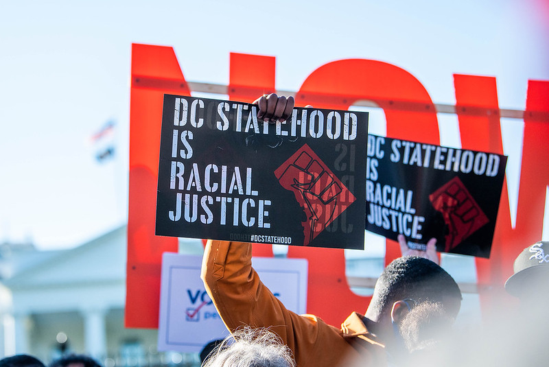 A man holding up a sign that says 