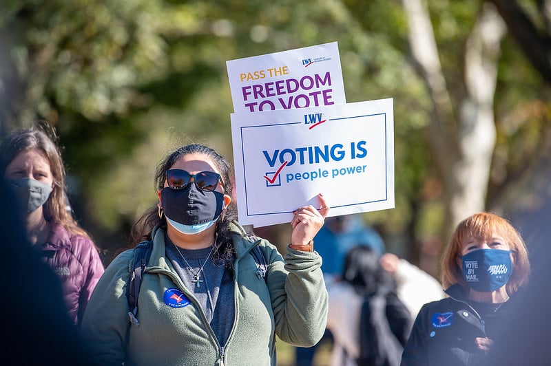 Woman holding pro-voting signs