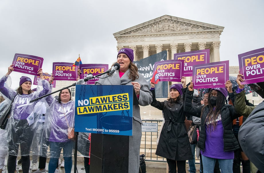 CEO Virginia Kase Solomòn speaking at the Moore v Harper rally with LWV staff standing behind her holding signs