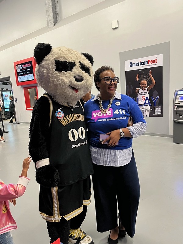CEO Celina Stewart posing with the mascot for the WNBA's Washington Mystics