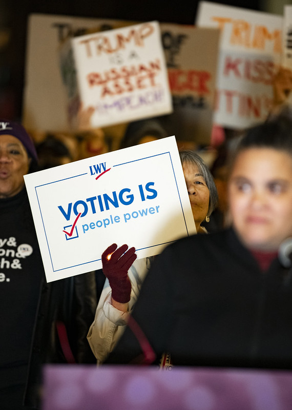 A woman holding a sign that says 