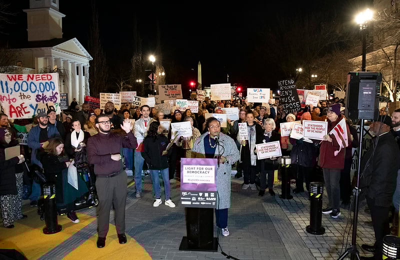 CEO Celina Stewart speaking at a podium in front of activists at a rally in DC