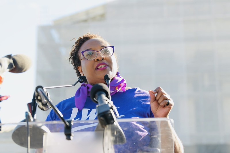 CEO Celina Stewart speaks at a podium in front of the Supreme Court