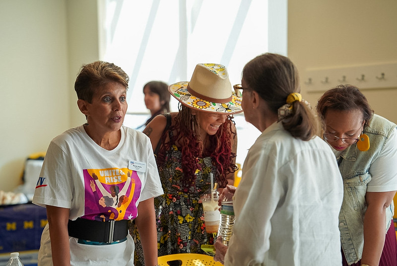 Board President Sania Irwin speaking with someone at a Unite and Rise event