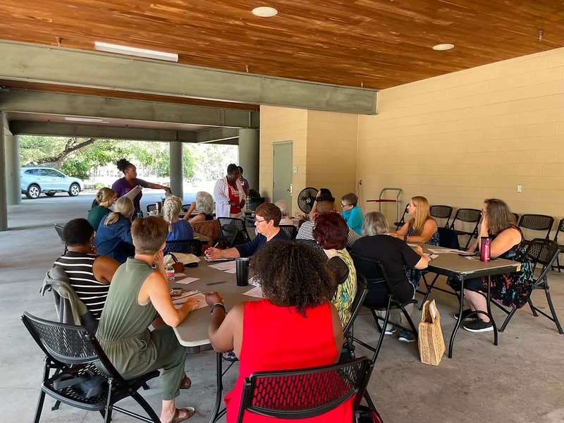 Participants in TX write postcards at folding tables