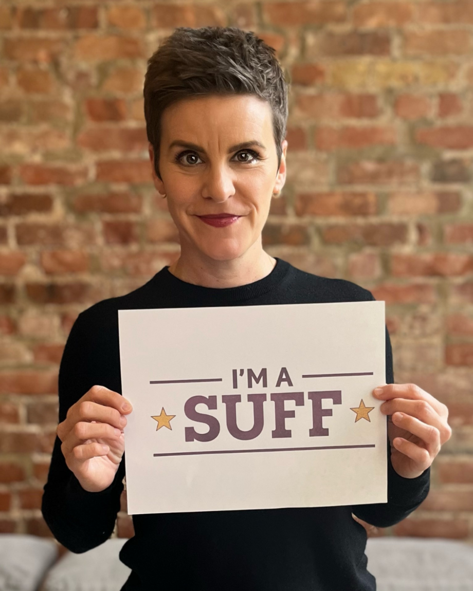 Suffs cast member Jenn Colella holding a sign that says 