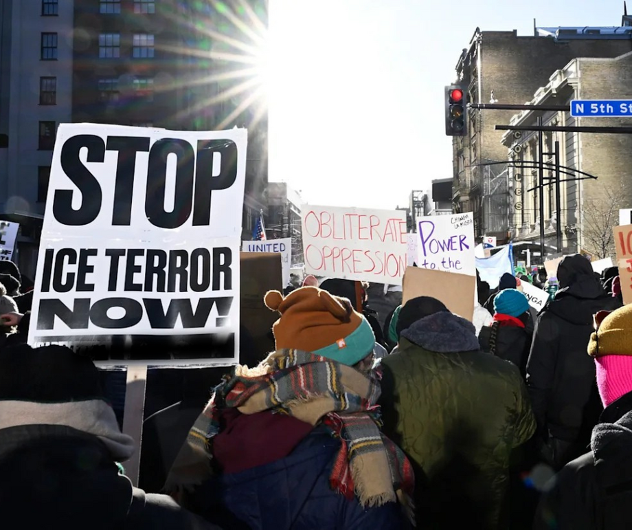 A crowd of protestors, one holding a sign that says 