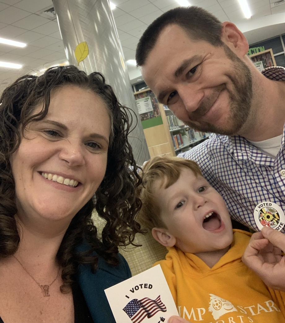 Two parents and a child holding up