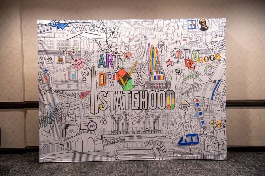 A large art piece depicting DC cultural icons with the words "Art Drives Statehood"