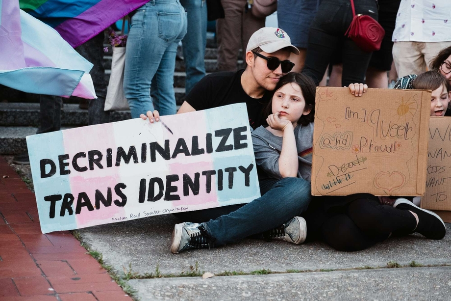 A parent and child holding a sign that says 