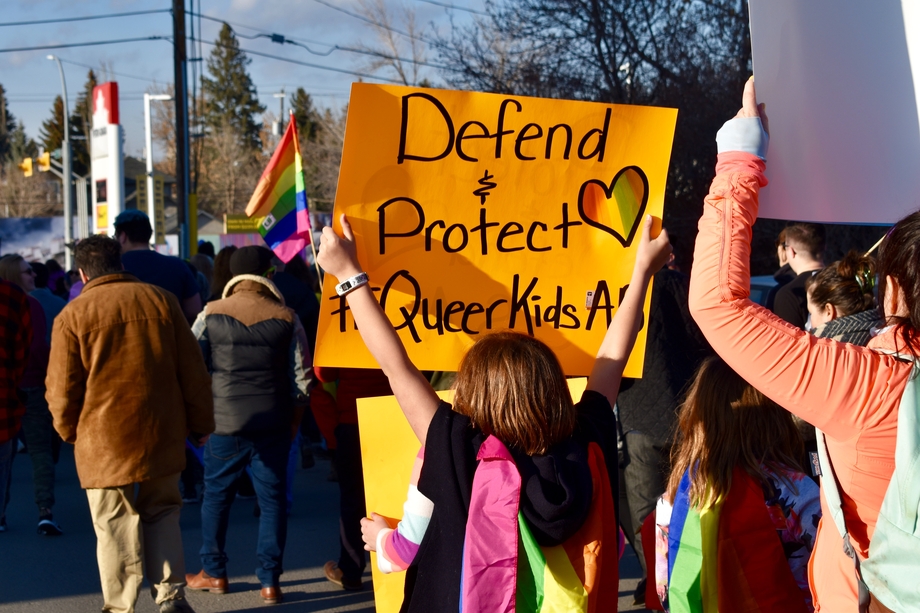 Protestors, one of whom holds a sign saying 