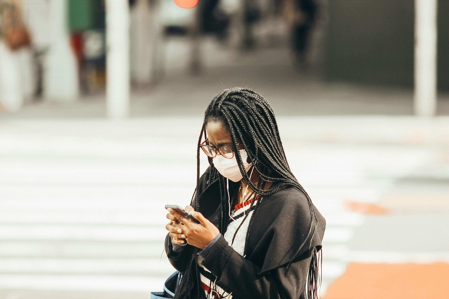 A woman wearing a face mask looking at her phone