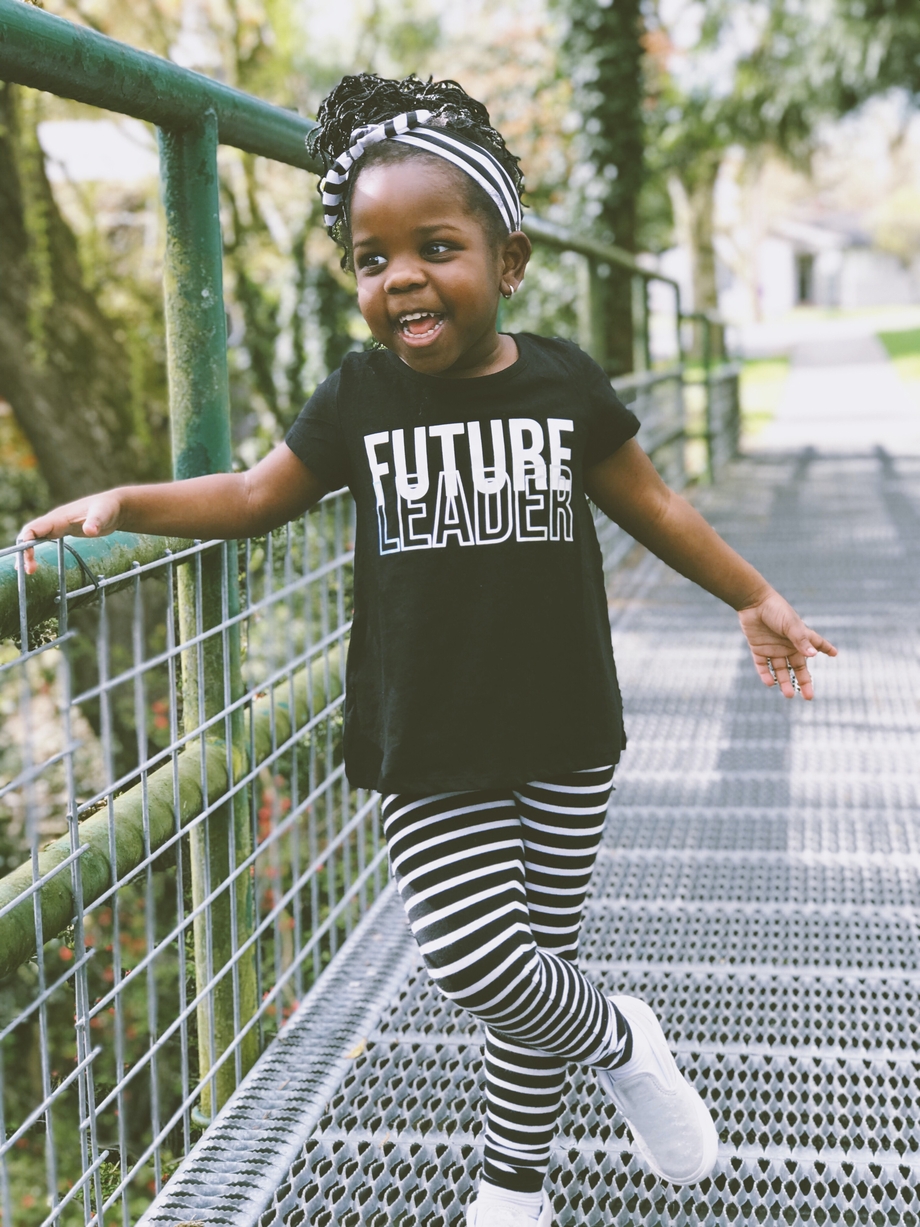 A young girl wearing a shirt that says 