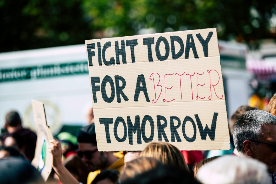 Person holding a protest sign that says