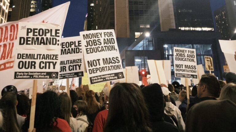 Protestors holding signs that say 
