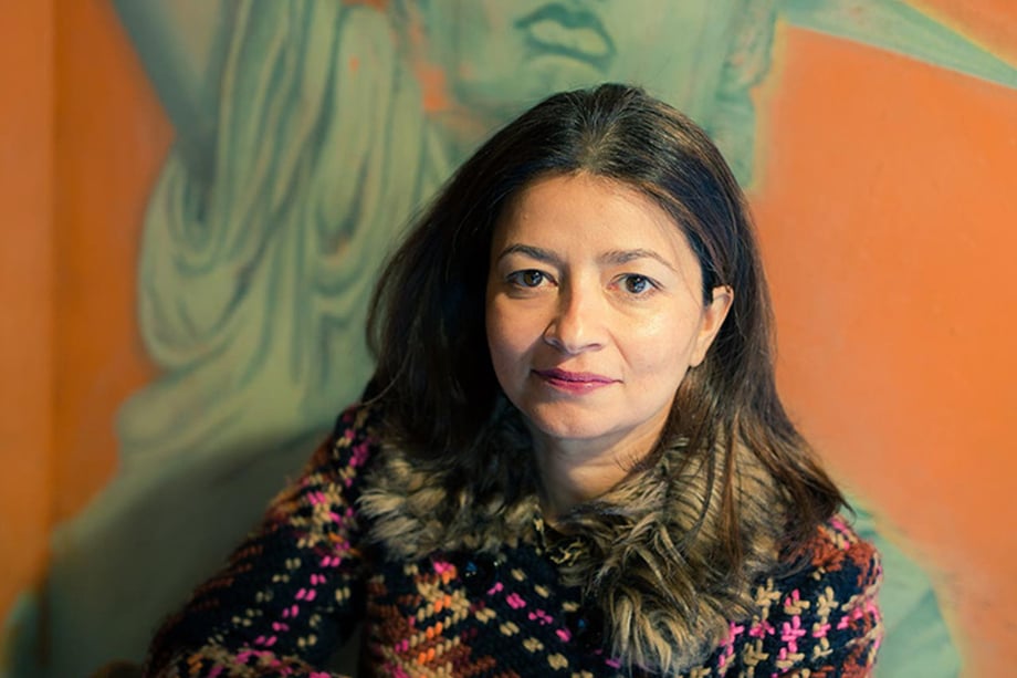 Headshot of Dr. Sayu Bhojwani in front of an orange wall